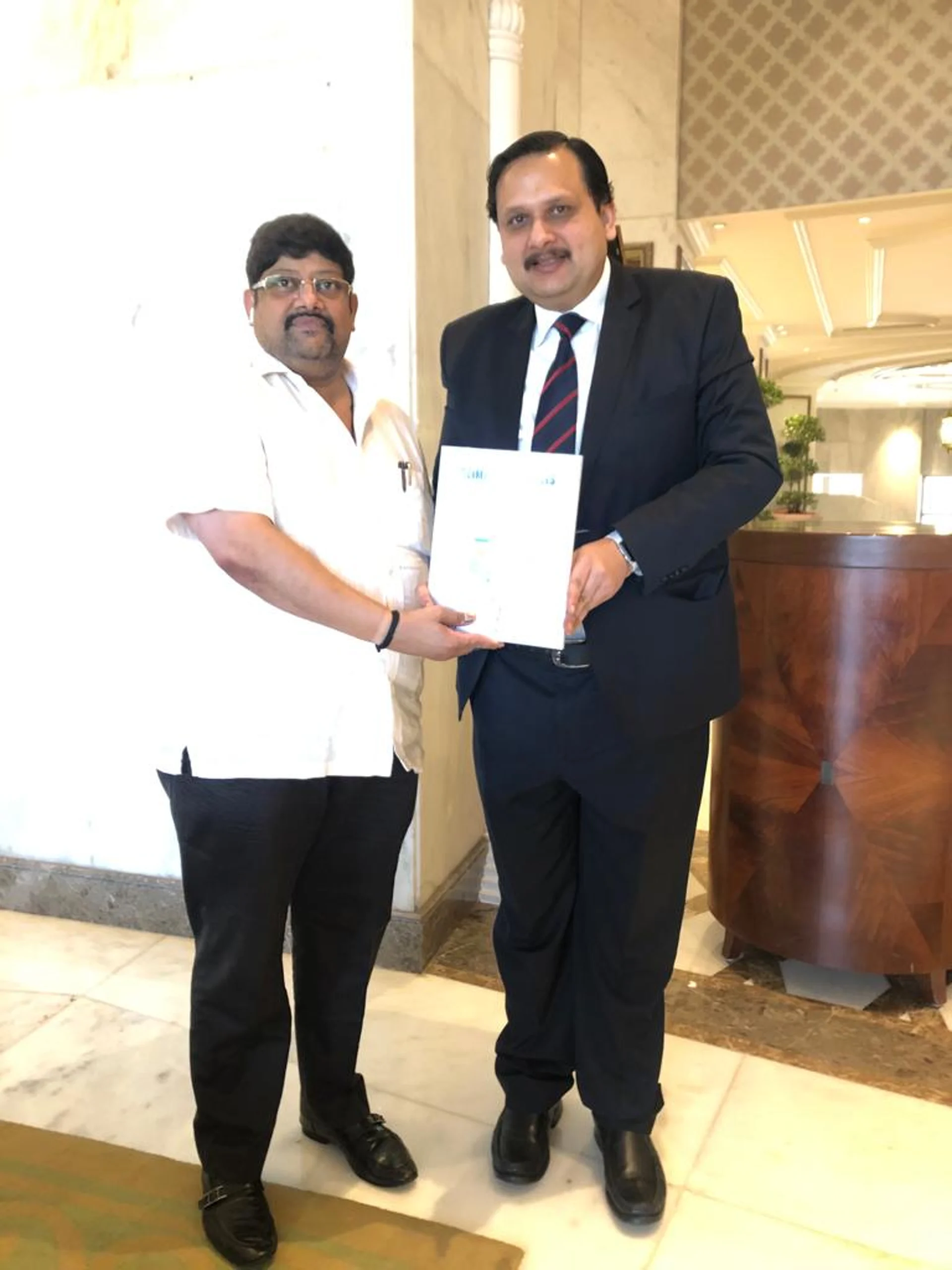 Rajesh Kaithwas exchanging a signed agreement with a business partner